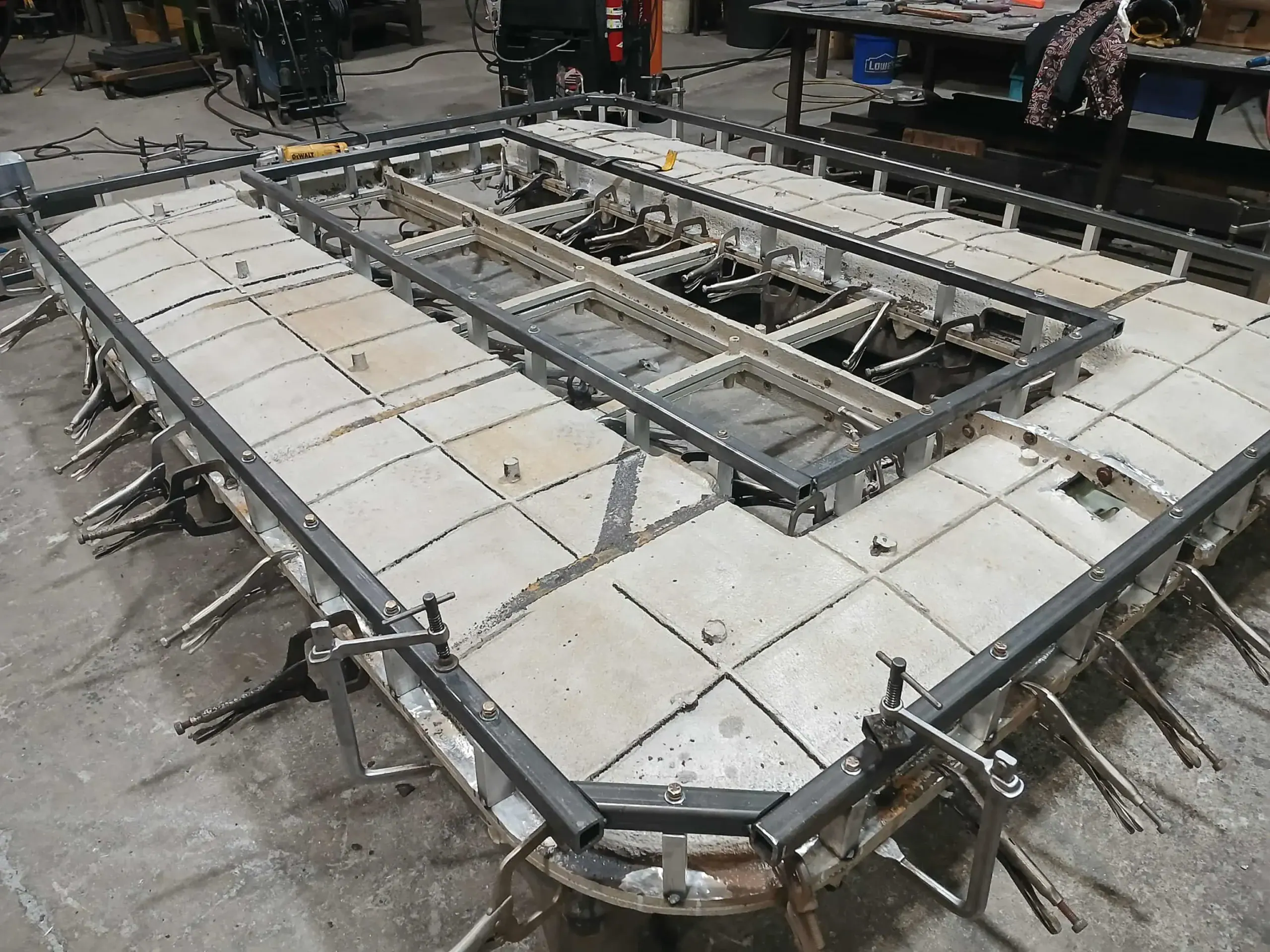 SG Burial Platform mold during restoration at Granger Plastics, showing additional supporting framework and temporary clamps around the realigned mold.